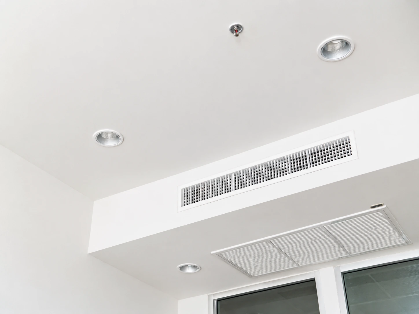 Griglia di ventilazione meccanica controllata nel soffitto bianco di una stanza