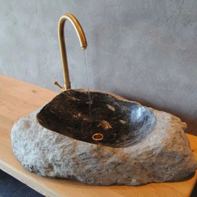 Lavabo in pietra naturale con rubinetteria in ottone su piano in legno